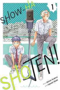 Cover of Show-ha Shoten! volume 1. Shijima is sitting on the ground, clasping his ankles so his knees are up by his elbows. Higashikata is standing next to him with one foot up on a curb and his hands wresting on the ledge above it. In front of them is a large microphone on a stand. Both boys are wearing their school uniform - plaid pants, white button-down shirts. Shijima is wearing his red tie.
